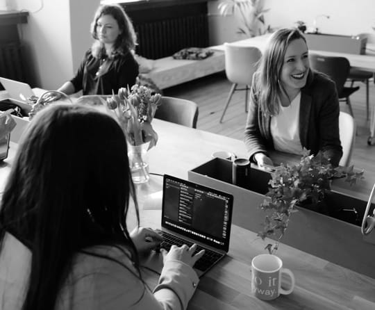 Women working and talking together in a cafe setting